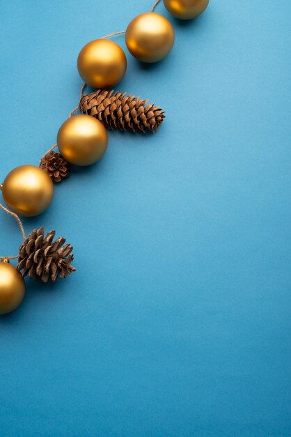 Gold Christmas balls and cones on a light blue background