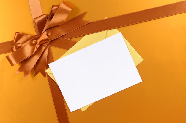 Foto nastro ed arco del fondo del regalo di natale dell'oro, etichetta del regalo o cartolina di natale