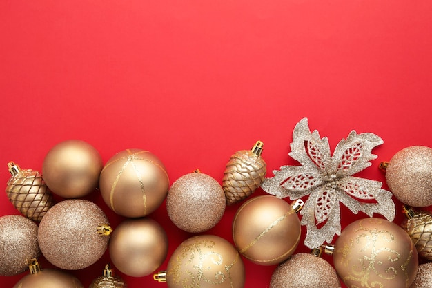 Decorazione dei giocattoli di natale dell'oro su fondo rosso con lo spazio della copia. biglietto di auguri di capodanno. stile minimale. disposizione piatta. vista dall'alto