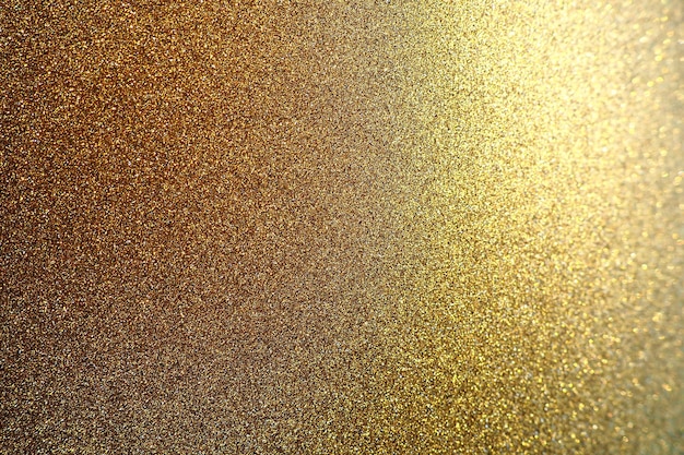 Gold close up. Golden glitter texture background. Sparkling glitter wrapping paper with sequins and sparkles. Festive golden bokeh and glitter. Beautiful background. Bokeh light of gold glitters.