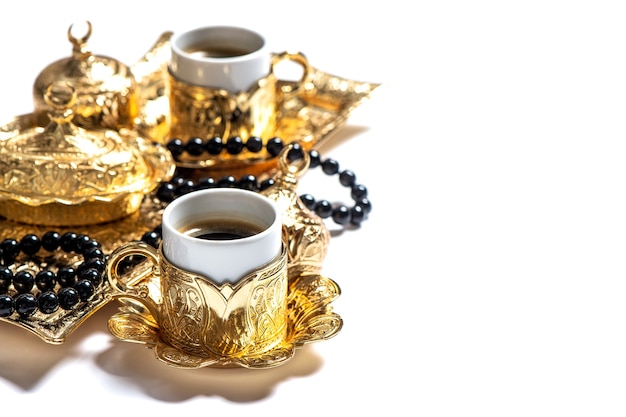 Gold coffee cups and rosary beads. Islamic holidays. Ramadan kareem