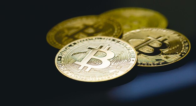 Gold coins of bitcoin on the surface of table with glass.