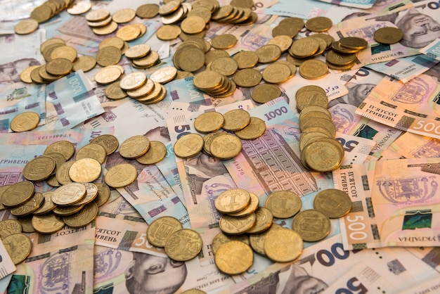 Золотые монеты лежат на банкнотах. Грн. Украинские деньги. Понятие о деньгах и экономии.