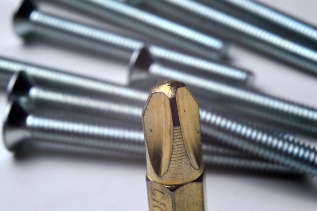 A gold-colored bit and a bolt lie close-up.