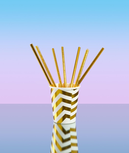 Gold colored paper drink straws in a festive cup on a gradient background Festive and colorful mood