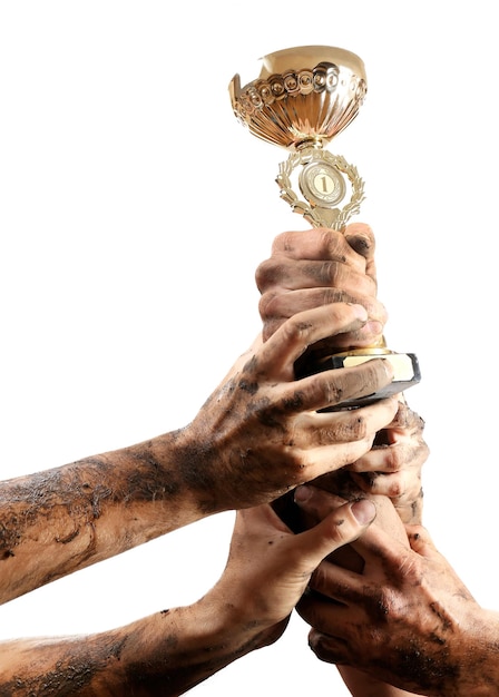 Photo gold cup in hands isolated on white