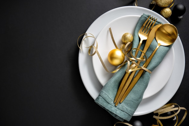 gold cutlery served on plate for christmas dinner