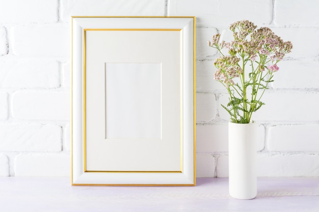 Photo gold decorated frame mockup with pink flowers in cylinder vase