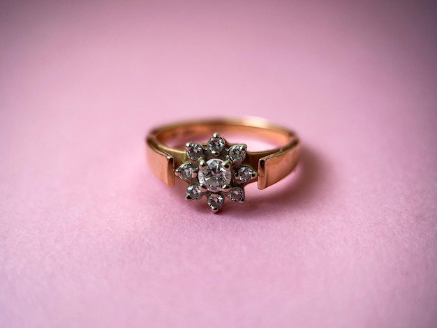 Gold diamond ring on pink isolated background red gold\
ring