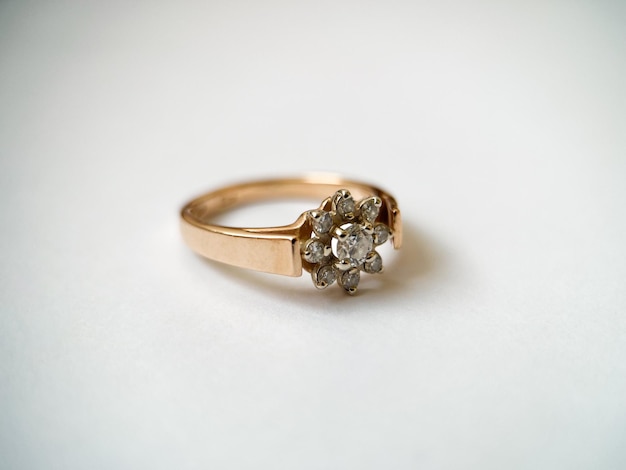 Золотое кольцо с бриллиантом на белом изолированном фоне Красное золотое кольцо