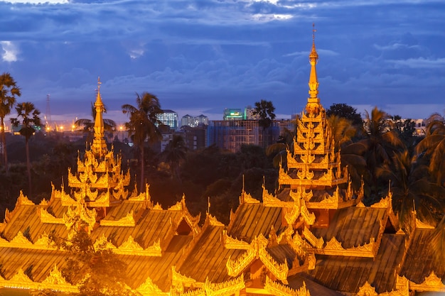 Gold domes of pagodas in Myanmar (Burma), blue twilight sky in the background. 