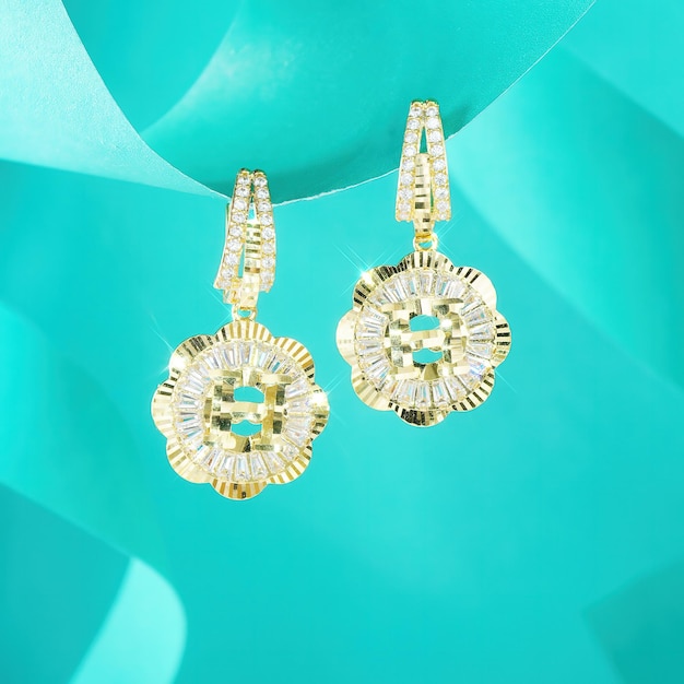 Photo a gold earring with a diamond center is on a turquoise background