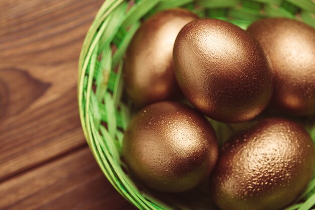 Gold eggs on wooden table