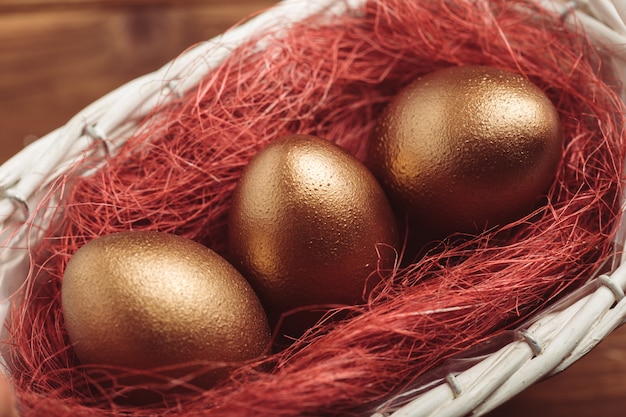 Gold eggs on wooden table