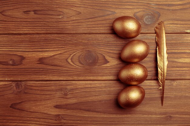 Gold eggs on wooden table