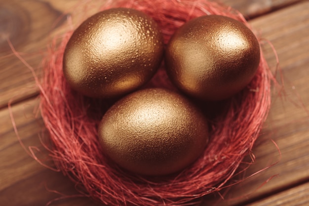 Gold eggs on wooden table