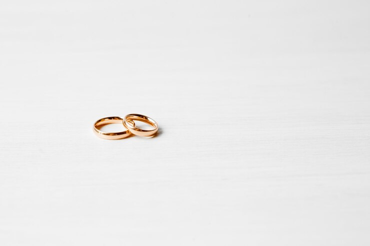 Photo gold engagement rings on white wall