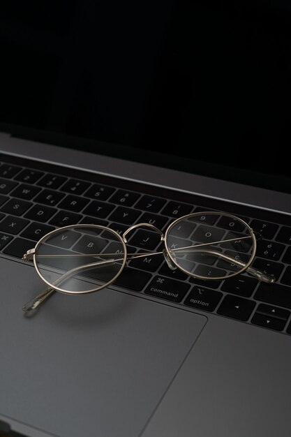 Gold eyeglasses on top of a computer keyboard