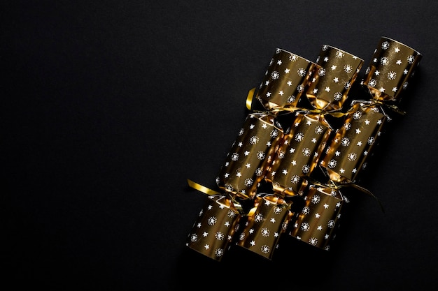 Gold festive Christmas crackers on a dark background