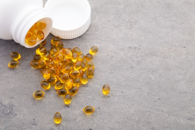 Gold fish oil scattered from pill bottle