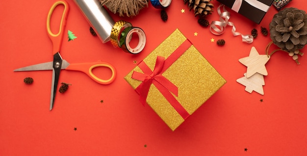 컴포지션을 휘게 하는 크리스마스 선물의 골드 선물 상자 밝은 빨간색 배경