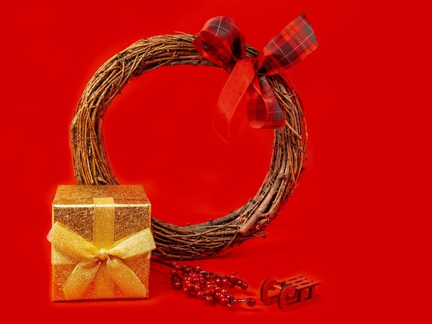 Photo gold gift box christmas wreath red background