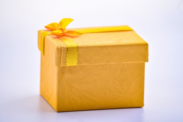 A gold giftbox on the white table, birthday, Christmas, Valentine day concept.