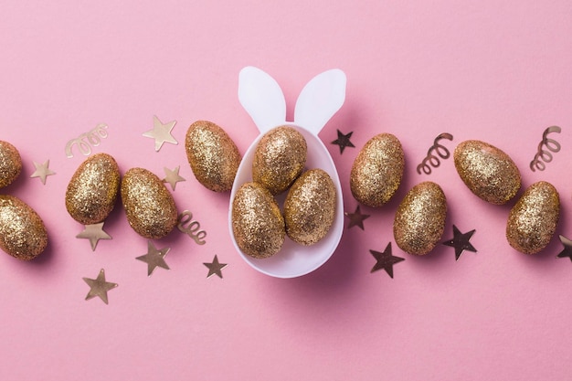 Gold glitter eggs in a white easter bunny egg shape with ears