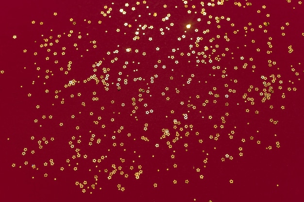 Foto stelle glitter oro su sfondo rosso scuro