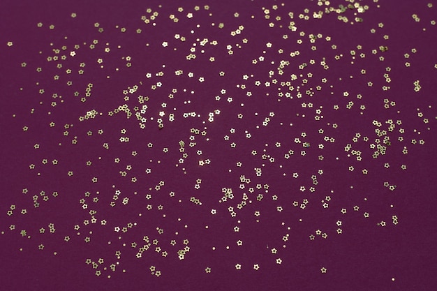 Gold glitter stars on a purple background