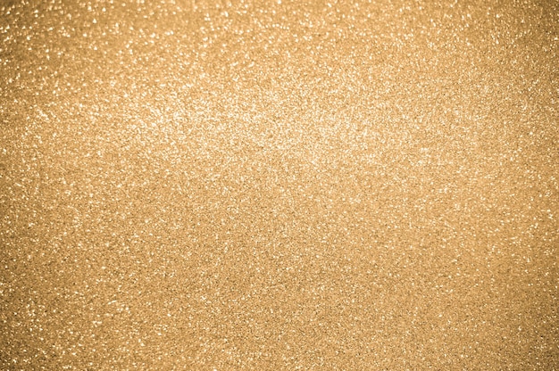 ゴールドのキラキラ背景きらめくぼかしスポット ライト ボケ光沢のあるゴールドの光の背景
