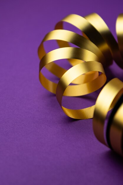 gold holiday ribbon on a purple matte surface