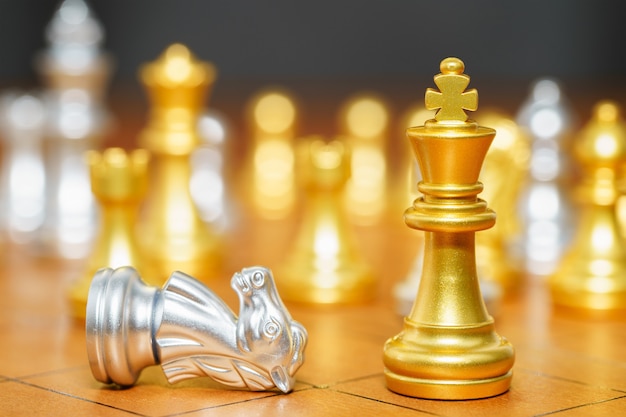 Gold king chess piece and horse chess pieces stand on wood chessboard ,Concept of leadership game of strategy