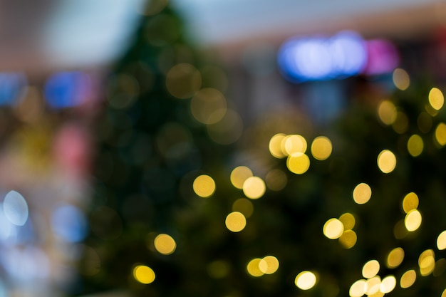 Photo gold light in christmas celebrate party, x'mas tree glitter and blurred lights background concept.