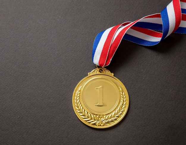 검은 배경에 고립 된 우승자를위한 스포츠 금메달 챔피언 트로피 수상 및 리본 상