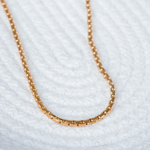 a gold necklace with a gold chain on it.