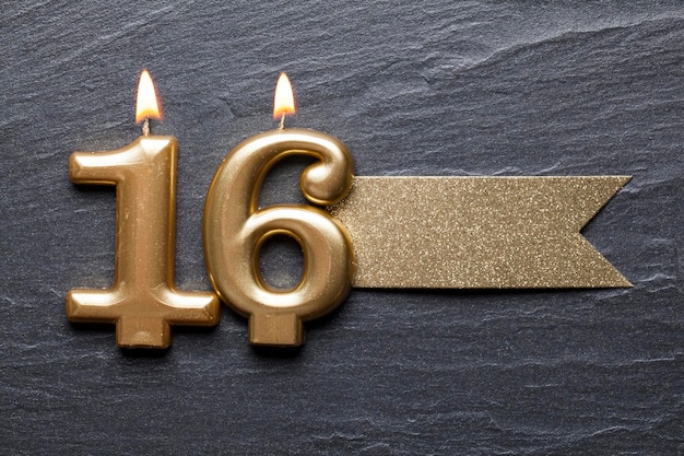 Gold number 16 celebration candle with glitter label