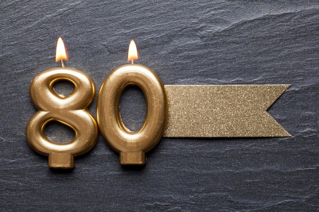 Gold number 80 celebration candle with glitter label