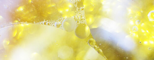 Фото Золотые нефтяные пузыри закрываются. круги воды макроса. абстрактный блестящий светло-желтый фон. баннер