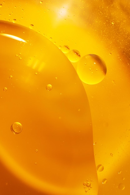 Gold Oil bubbles close up circles of orange water macro abstract shiny yellow background