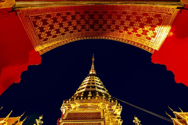 Gold pagoda and buddha statue in Wat Doi Suthep temple at night