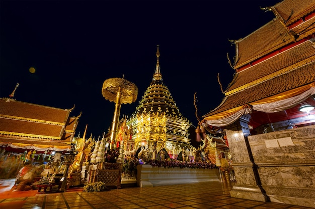 Photo gold pagoda and buddha statue in wat doi suthep temple at night