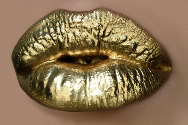 Vernice dorata sulle labbra bocca sensuale della donna delle labbra dorate