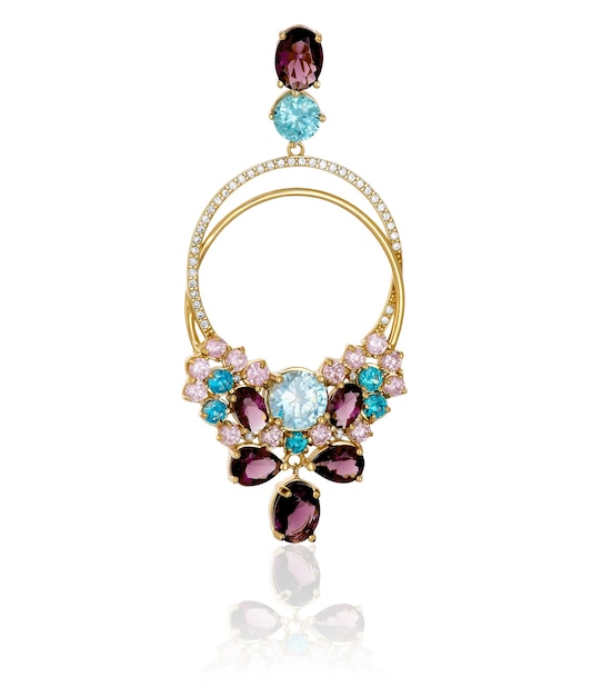 Gold pendant with colored stones on a white background with reflection