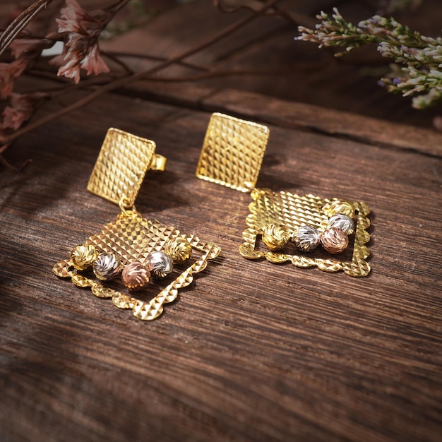 Gold Pierced Earrings on background wood