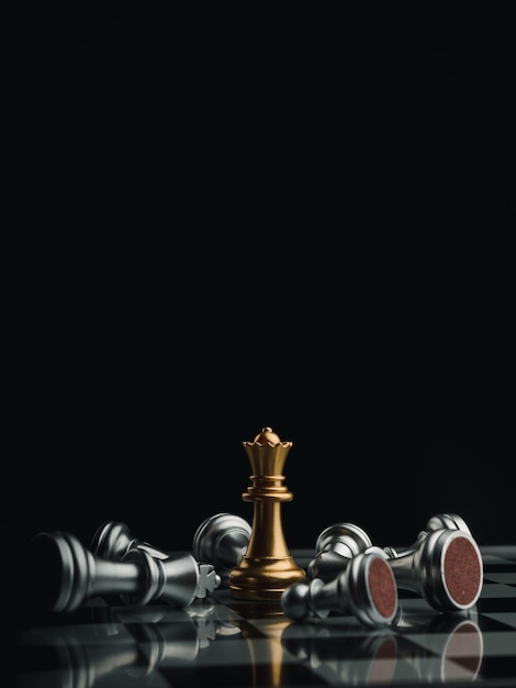 Photo the gold queen chess piece standing with falling silver pawn chess pieces on chessboard on dark background with copy space, vertical style. leadership, winner, competition, business strategy concept.