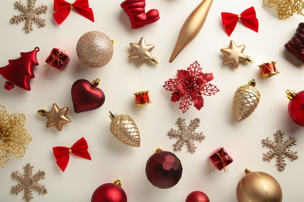 Золотые и красные рождественские украшения на белом фоне, вид сверху, плоская планировка. Новогодняя композиция