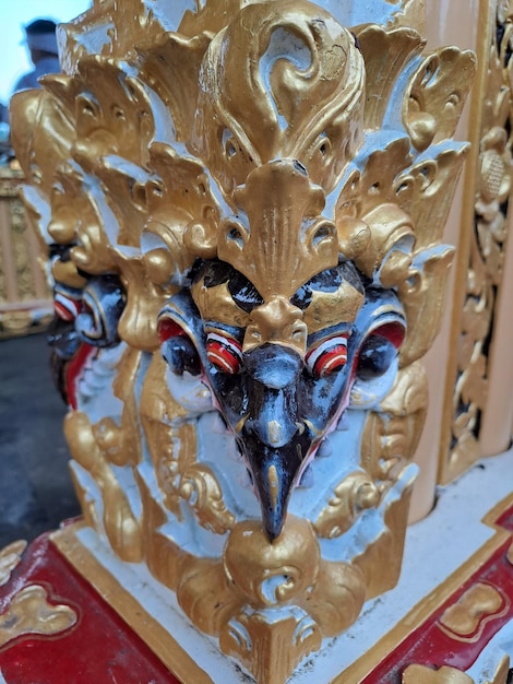 A gold and red piece of furniture with a face on it.