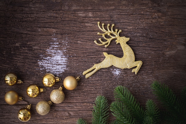 Золотой олень с безделушка на деревянный стол, рождественские украшения фона.
