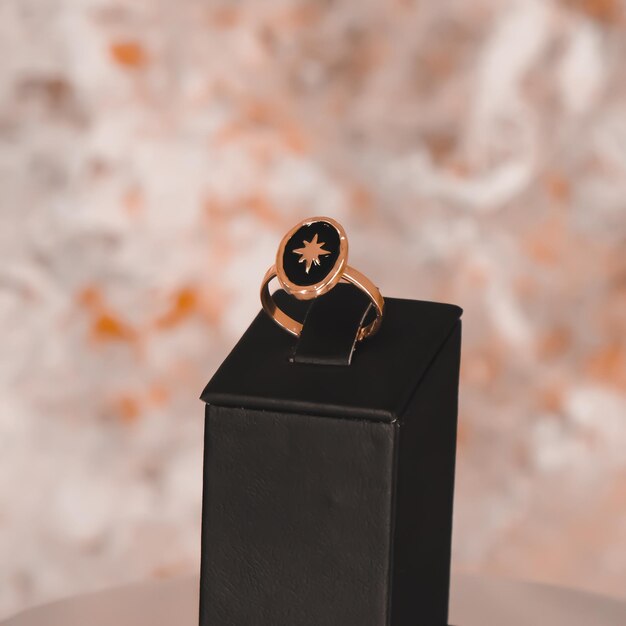 A gold ring with a black ring on top of a black box.